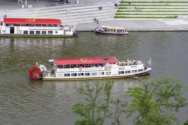 Wroclaw Polonya - 16 Haziran 2022: Turistler arka planda modern bir gezinti alanı bulunan Odra Nehri 'nde yüzen kürek tekneleriyle nehir turunun keyfini çıkarıyorlar.
