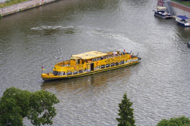 Wroclaw Polonya - 16 Haziran 2022: Sarı bir su taksisi Odra Nehri 'nde yüzüyor ve şehir yaşamını gözler önüne seriyor.