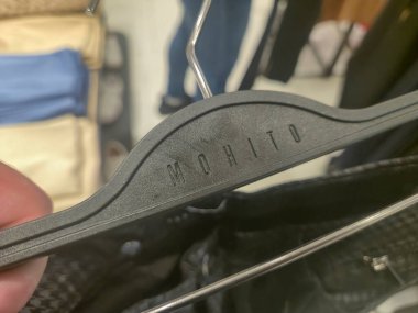 Przemysl Polonya - Mart 12025: Mohito etiketli siyah bir askıya yakın çekim, perakende satış ortamında moda ve giyim tarzını vurgulayan bir marka sergiliyor.