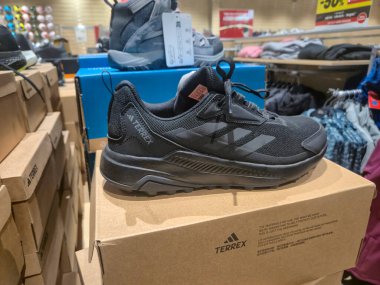 Przemysl Polonya - Mart 12025: Modern ayakkabı tasarımının sergilendiği bir perakende mağazasının içindeki bir karton kutuda sergilenen siyah Terrex spor ayakkabılarına yakından bakmak.