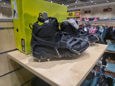 Przemysl Poland - Mart 12025: Bir spor mağazasının ahşap rafında sergilenen siyah kar botları kış sporu meraklılarına özel tasarım ve işlevsellik sergiliyor.