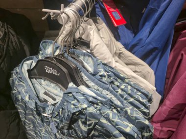 Przemysl Poland - Mart 12025: Moda eğilimlerini vurgulayan çeşitli ceket ve gömleklerin sergilendiği bir mağaza perakendecisinde renkli giysilerin sergilenmesi.