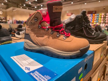 Przemysl Poland - Mart 12025: Açık hava teçhizatını vurgulayan bir perakende mağazasında kahverengi yürüyüş botları sergileniyor. Dayanıklı ayakkabılar arayan macera düşkünleri için mükemmel..