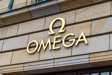 Berlin Almanya - 11 Nisan 2025: Markanın logosunu gösteren zarif bir Omega mağaza tabelasının yakın çekimi yoğun bir şehir ortamında lüks ve sofistike bir görünüm sergiliyor.