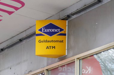Berlin Almanya - 11 Nisan 2025: Euronet damgalı açık sarı bir ATM tabelasının yakın çekimi sokaklarda mevcut finans hizmetlerini gösteriyor.