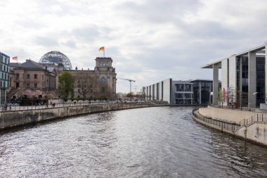 Berlin Almanya - 11 Nisan 2025: Spree Nehri boyunca tarihi ve modern mimarinin yer aldığı manzara manzarası.