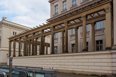 Berlin Almanya - 11 Nisan 2025: Klasik sütunları ve modern unsurları olan tarihi bir binanın mimari ayrıntıları geçmiş ve günümüzün bir karışımını oluşturuyor.
