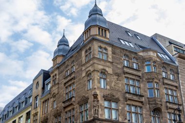 Berlin Almanya - 11 Nisan 2025: Karmaşık taş işçiliği ve süslü camlı tarihi bina, Berlin 'in kent ortamındaki mimari tarihinin özünü yansıtıyor.