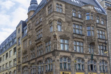 Berlin Almanya - 11 Nisan 2025: Süslü oymalar ve detaylı mimarinin yer aldığı tarihi bina cephesi bulutlu bir gökyüzüne karşı çekilen şehir mirası sergileniyor.