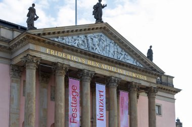 Berlin Almanya - 11 Nisan 2025: Ünlü Berliner Tiyatro Topluluğu 'nun dış görünüşü klasik mimari sergilenirken, heykeller önünde etkinlikler ilan ediliyor.