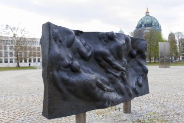 Berlin Almanya - 11 Nisan 2025: Dinamik pozlarda insan figürlerini tasvir eden sanatçı tarafından yapılan çağdaş heykel tarihi mimari yakınlarındaki bir kamusal alanda yer alıyor.
