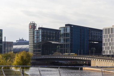 Berlin Almanya - 11 Nisan 2025: Rıhtım kenti boyunca uzanan modern mimari yapılar, kentsel alanları birbirine bağlayan bir köprü ile cam ve çelik yapılardan oluşan bir karışıma sahip..
