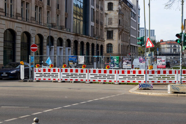 Берлин Германия - 11 апреля 2025 года: Городская улица в Берлине со строительными барьерами с светофорами в окружении современных зданий и плакатов, демонстрирующих активность города.