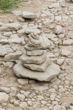 Kayalık bir yolda dikkatlice dengelenmiş taşlar yığını uyum ve doğa güzelliğini sembolize ediyor. Bu kompozisyon, zenginlik temaları için ideal doku ve toprak tonlarını vurgular.