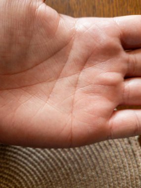 İnce deri dokularını ve dokulu yüzeyde duran ince çizgileri gösteren insan avucunun yakın görüntüsü. El detaylarını vurgulayan basit bir doğal kompozisyon..