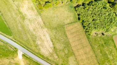 Çeşit çeşit yeşil alanların havadan görünüşü, dolambaçlı bir yol ile kesişiyor. Tarım arazileri ve huzurlu kırsal bölgelerdeki ormanlık alanlarla kesişiyor..