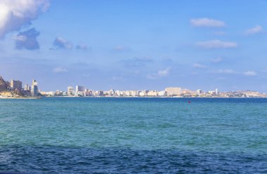 Alicante İspanya kıyı manzarası canlı bir mavi deniz ve berrak güneşli gökyüzü altında modern binalarla dolu bir ufuk çizgisi seyahat ya da emlak temaları için mükemmel.