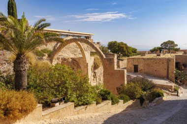 Alacant İspanya 'daki tarihi taş kemer yolu yemyeşil ve doğal manzaralarla çevrili. Güneşli bir günde eski yapıların mimari güzelliği ve dokusu vurgulanır..