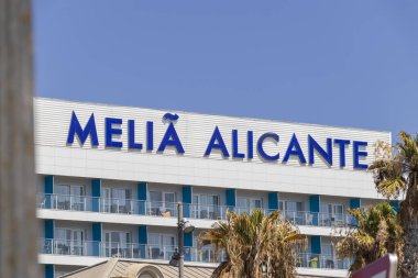 Alicante İspanya - 11 Temmuz 2025: Melia Alicante Oteli, açık gökyüzüne karşı canlı mavi harflerle modern mimariyi sergiliyor ve misafirler için hoş bir ortam yaratıyor.