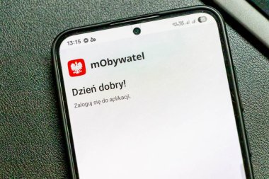 Varşova Polonya - 15 Nisan 2025: MObywatel uygulamasının dostça bir selamlama ve giriş komutunu içeren bir akıllı telefon ekranının yakın çekimi.