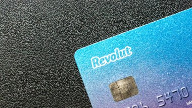 Varşova Polonya - 15 Nisan 2025: Bir Revolut bankamatik kartının yakın çekimi mavi gradyan tasarımını desenli siyah bir yüzeye yerleştirdi.