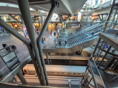 Berlin Almanya - 16 Nisan 2025: Yolcular Berlin Hauptbahnhof İstasyonu 'nda modern mimari ve hareketli atmosferi bir geçiş merkezi içinde sergiliyor.