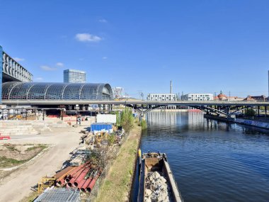 Berlin Almanya - 16 Nisan 2025: Modern köprü ve nehir kıyısı boyunca inşa edilen Hauptbahnhof manzarası açık mavi gökyüzü altında kentsel gelişimi gösteriyor.