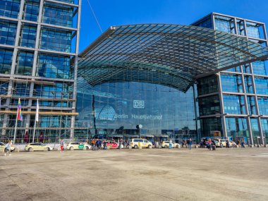 Berlin Almanya - 16 Nisan 2025: Berlin Hauptbahnhof 'un cam cepheli modern mimarisi. Gündüz vakti taksiler ve yayalarla dolu ulaşım merkezi.