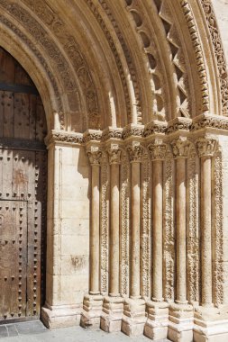 Karmaşık oymalar ve Valencia 'nın zengin tarihsel mirasının sergilendiği ahşap bir kapı içeren antik taş kemer yolunun güzel mimari detayları..
