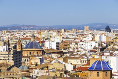 Valencia 'nın panoramik bir görüntüsü şehir manzarasını belirgin çatılarıyla özellikle açık mavi gökyüzü ortamındaki kubbelerle vurguluyor. Seyahat ve mimari temalar için mükemmel.