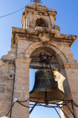 Açık mavi gökyüzüne karşı büyük bir çan kulesi olan tarihi çan kulesi. Mimari detaylar Valencia 'daki kültürel önemini vurgulayan antik taş çalışmalarını gözler önüne seriyor.
