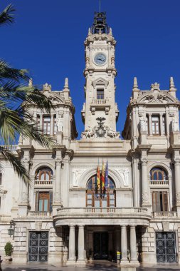 Valencia Ayuntamiento de Valencia, kültür mirası ve şehir yönetimini temsil eden açık mavi gökyüzünün altında çarpıcı bir mimari ve belirgin bir saat kulesi sergiliyor..