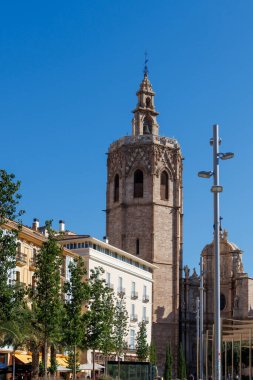 Valencia 'daki ikonik çan kulesi, canlı şehir atmosferi ve modern mimari için tarihi bir zemin sağlayan açık mavi gökyüzüne karşı görkemli bir şekilde ayakta duruyor..