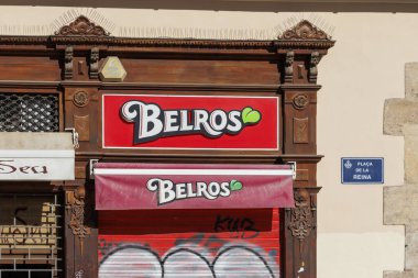 Valencia İspanya - 13 Temmuz 2025: Belros şekerci dükkanının parlak tabelaları büyüleyici Plaza de la Reina 'da yerel kültürü gözler önüne seren klasik mimariyle süslendi.