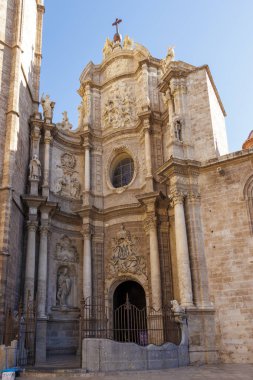 Valencia İspanya - 13 Temmuz 2025: Valencia Katedrali 'nin karmaşık cephesi açık mavi gökyüzü altında süslü heykeller ve tarihi mimari sergiliyor..