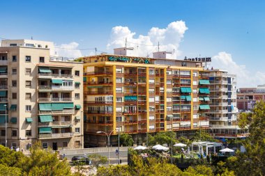 Alicante İspanya - 12 Temmuz 2025: Parlak mavi gökyüzü altındaki renkli konut binaları, kendine özgü mimari ve canlı çevreyi gözler önüne seren şehir yaşamına bir bakış sunuyor.