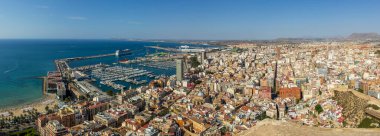 Alicante 'nin panoramik manzarası canlı kıyı şehrini modern binaları ve açık mavi gökyüzü altında Akdeniz' i gözler önüne seriyor..