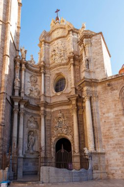 Valencia İspanya - 13 Temmuz 2025: Valencia Katedrali 'nin karmaşık cephesi açık mavi gökyüzü altında süslü heykeller ve tarihi mimari sergiliyor..