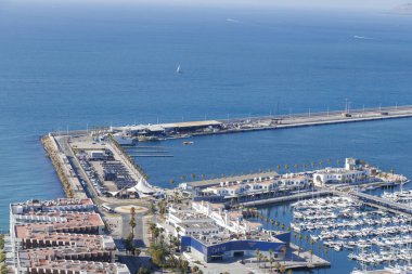 Alicante İspanya - 12 Temmuz 2025: Alicante 'deki canlı yat limanının hava manzarası açık gökyüzü altında açık mavi denize karşı tekneler ve güzel kıyı şeridi.