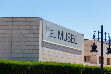 Valencia İspanya - 13 Temmuz 2025: El Museo tabelası açık mavi gökyüzü altındaki yemyeşil yemyeşil ile çevrili Valencia 'daki modern bir müze binasında belirgin bir şekilde sergilendi.
