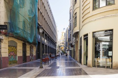 Valencia İspanya - 13 Temmuz 2025: Valensiya 'da modern mimari ve açık gökyüzü altındaki bankların yer aldığı boş cadde şehir yaşamı ve şehir keşiflerini gözler önüne seriyor.