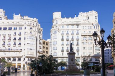 Valencia İspanya - 13 Temmuz 2025: Güzel Plaza del Ayuntamiento açık mavi gökyüzü altında beyaz binalar ve merkezi bir heykel ile çarpıcı bir mimari sergiliyor.