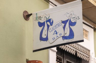 Alicante İspanya - 12 Temmuz 2025: Claustro 4 Bar için klasik tabela mavi giyinmiş iki kişi yerel yemek kültürünü çevreleyen neşeli bir atmosfer sergiliyor.