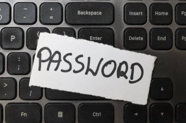 PASSWORD kelimesi bilgisayar klavyesinde siber güvenlik kavramlarını ve şifre yönetim temalarını vurgulayan yırtık bir kağıt parçasında görüntülenir.
