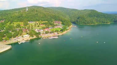 Solina Gölü 'nün panoramik manzarası. Dağınık tekneler ve yemyeşil tepeler güneşli bir günde çekildi..