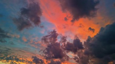 Dramatik gün batımı gökyüzü, turuncu ve mavi tonlarında canlı bulutlar, havadan görüntüler..