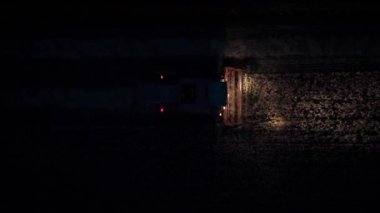 Geceleri karanlık bir ekin tarlasında hareket eden bir hasatçının yukarıdan aşağıya havadan çekilmiş görüntüsü..