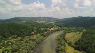 Nehir vadisinin yemyeşil bitki örtüsü ve kayan tepeleriyle panoramik görüntüsü..