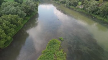 Net suların yoğun yeşil ağaçlar ve ormanlık alanlar arasında aktığı bir nehrin havadan görünüşü.