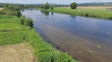 Suyun altında su bitkilerinin görüldüğü temiz ve sığ bir nehrin havadan görüntüsü..